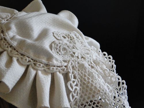 The crown is trimmed with narrow lace.  Detail of lace jabot used as streamers.
